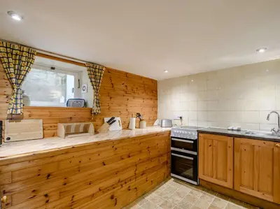 a kitchen with wooden walls and a counter top at 1 Bed in Eskdale SZ503 in Beckfoot