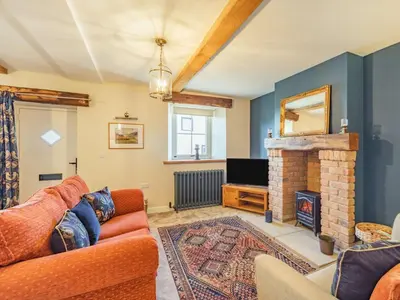 a living room with a couch and a fireplace at 3 Bed in Bridekirk 85717 in Bridekirk