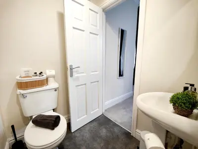 a white bathroom with a toilet and a sink at Cranford House in Keswick