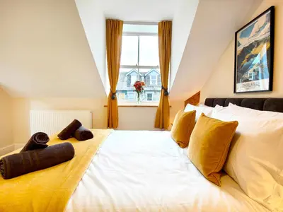 a large white bed in a room with a window at Cranford House in Keswick