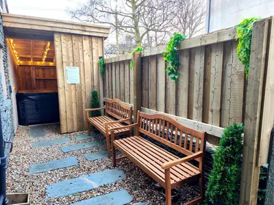 two wooden benches sitting in front of a fence at Cranford House in Keswick