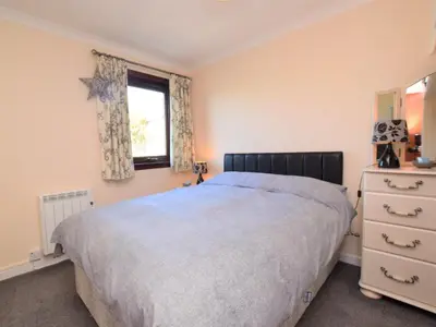 a bedroom with a large bed and a window at 2 Bed in Isle of Whithorn 77880 in Isle of Whithorn