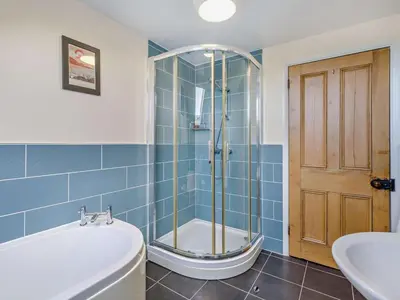 a bathroom with a tub and a shower and a sink at 5 Bed in Cleator oc-sz529 in Ennerdale Bridge