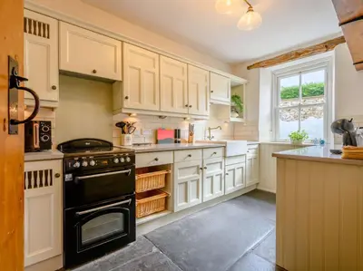 a kitchen with white cabinets and a black stove at 3 Bed in Ennerdale Bridge SZ392 in Ennerdale Bridge
