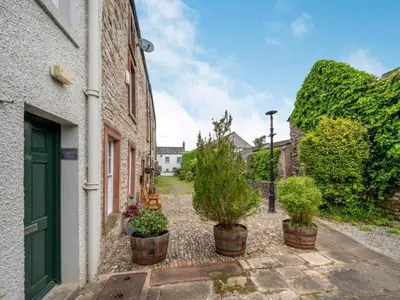 a courtyard with potted plants in front of a building at 2 Bed in Cockermouth oc-87481 in Cockermouth