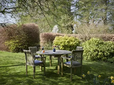 a table and chairs in a yard with a fountain at 2 Bed in Boltongate SZ396 in Mealsgate