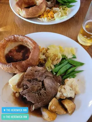 two plates of food with meat and vegetables on a table at The Herdwick Inn in Penruddock