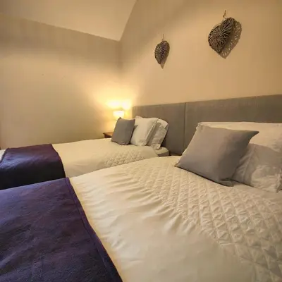 a bedroom with two beds and two hearts on the wall at The Herdwick Inn in Penruddock
