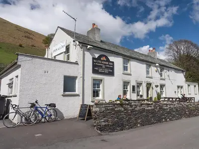 a white building with bikes parked in front of it at 3 Bed in Threlkeld SZ083 in Threlkeld