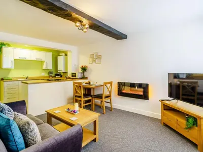 a living room with a couch and a table and a kitchen at 2 Bed in Cockermouth 85514 in Cockermouth