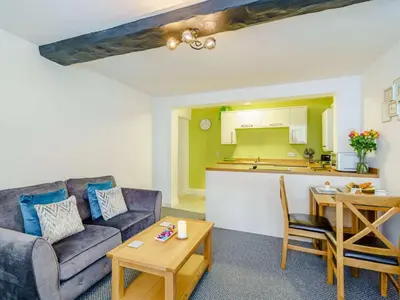 a living room with a couch and a table and a kitchen at 2 Bed in Cockermouth 85514 in Cockermouth