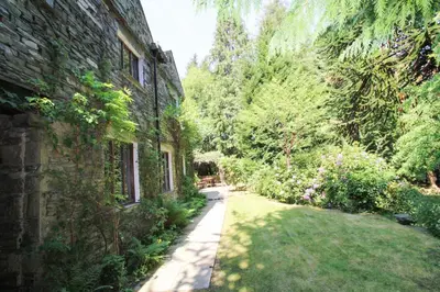 an empty garden next to a brick building at Daweswood, Patterdale, characterful with fairy tale garden and fell walks from the door in Patterdale
