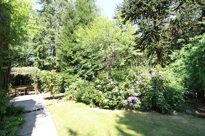 a garden with a bench and flowers and trees at Daweswood, Patterdale, characterful with fairy tale garden and fell walks from the door in Patterdale