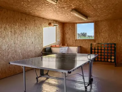 a ping pong table in the middle of a room at The Longhouse At Threave in Castle Douglas