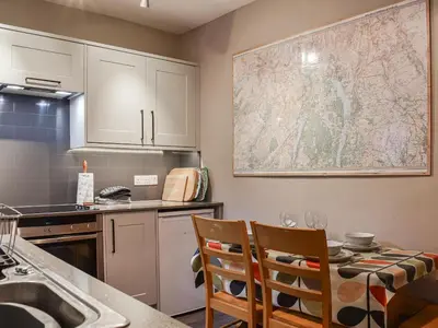 a kitchen with a table and chairs and a map on the wall at Lingmoor View in Ambleside