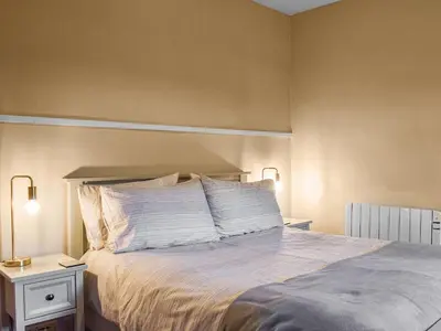 a bedroom with a bed with white sheets and pillows at Lingmoor View in Ambleside