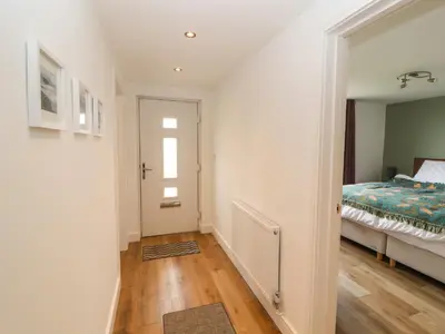 a bedroom with a bed and a hallway with a door at Cherry Croft in Wigton