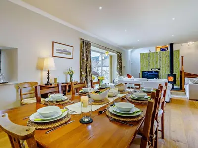 a dining room and living room with a wooden table at 4 Bed in Moffat 82374 in Moffat