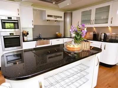 a kitchen with black counter tops and white cabinets at 4 Bed in Moffat 82374 in Moffat