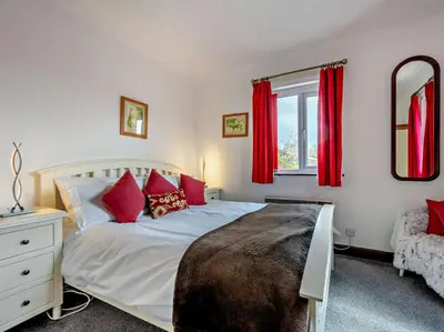 a bedroom with a bed and a window with red curtains at 4 Bed in Troutbeck nr Ullswater SZ256 in Troutbeck