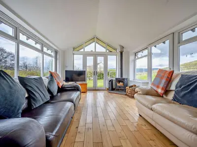 a living room with a leather couch and a fireplace at 4 Bed in Troutbeck nr Ullswater SZ256 in Troutbeck