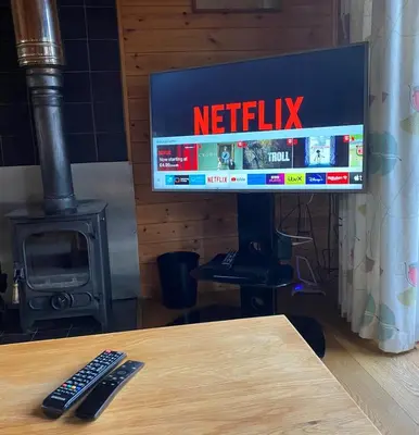 a television with a netflix sign on a table at Buzzard Lodge with Hot-tub in Carlisle