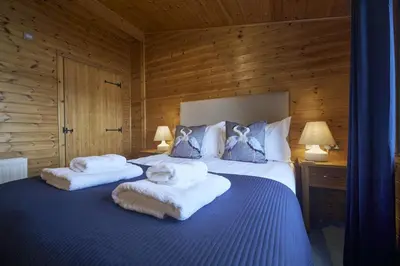 a bedroom with two towels on top of a bed at Buzzard Lodge with Hot-tub in Carlisle