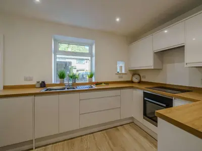 a kitchen with white cabinets and a window at 2 Bed in Glenridding 85425 in Glenridding