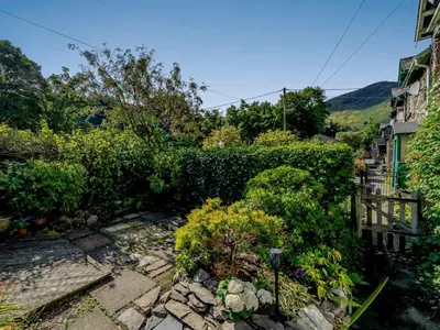 a garden with a stone path and bushes at 2 Bed in Glenridding 85425 in Glenridding