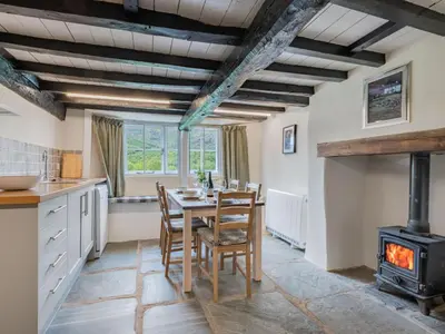 a kitchen and dining room with a table and a stove at 3 Bed in Seathwaite SZ107 in Eskdale