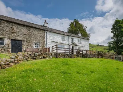 an old stone house with a fence and a yard at 3 Bed in Seathwaite SZ107 in Eskdale
