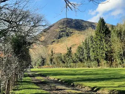 a mountain in the middle of a field with trees at 1 bed property in Keswick 86117 in Braithwaite