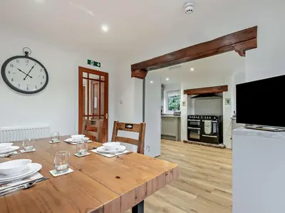 a dining room with a table and a clock on the wall at 2 Bed in Rosthwaite 86397 in Rosthwaite