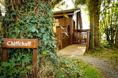 a sign in front of a building with a wooden door at Chiffchaff Lodge with Hot tub in Carlisle