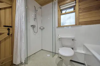 a bathroom with a toilet and a glass shower at Chiffchaff Lodge with Hot tub in Carlisle