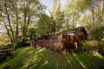 an old train car sitting in the grass at Chiffchaff Lodge with Hot tub in Carlisle