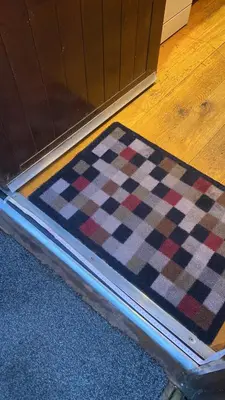 a checkered rug on a floor next to a door at Dunnock Lodge with Hot-tub in Carlisle