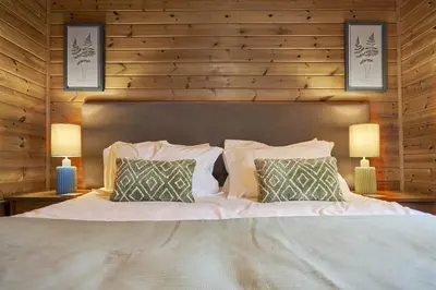 a bedroom with a large bed with two lamps at Dunnock Lodge with Hot-tub in Carlisle