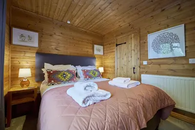 a bedroom with a bed with towels on it at Dunnock Lodge with Hot-tub in Carlisle