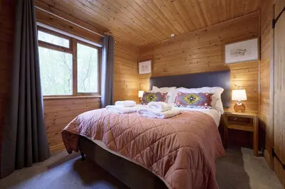 a bedroom with a bed with towels on it at Dunnock Lodge with Hot-tub in Carlisle