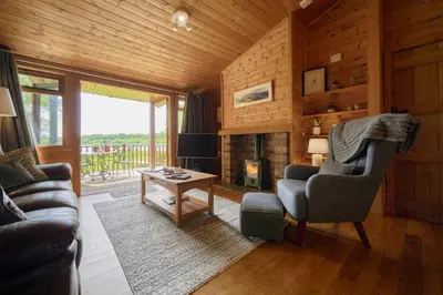 a living room with a couch and a chair and a fireplace at Egret Lodge with Hot-tub in Carlisle