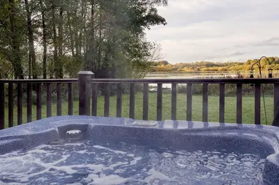 a jacuzzi tub with a view of the water at Egret Lodge with Hot-tub in Carlisle