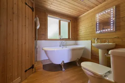 a bathroom with a tub and a sink and a toilet at Egret Lodge with Hot-tub in Carlisle