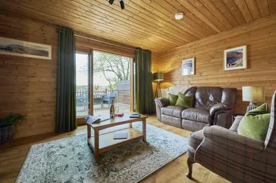 a living room with a couch and a table at Gadwall Lodge with Hot-tub in Carlisle