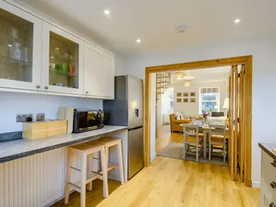 a kitchen and living room with a table and a microwave at 3 Bed in Lockerbie 89406 in Lockerbie