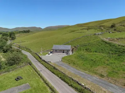 an aerial view of a house on a hill with a road at 3 Bed in Moffat oc-ca402 in Moffat