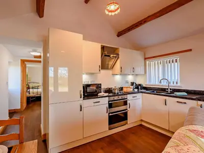 a kitchen with white cabinets and a stove top oven at 1 Bed in Allonby 28791 in Allonby