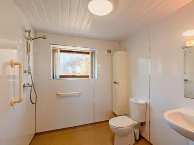 a bathroom with a toilet and a sink and a window at 1 Bed in Allonby 28791 in Allonby