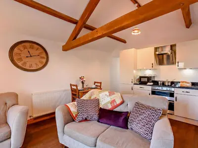 a living room with a couch and a clock on the wall at 1 Bed in Allonby 28791 in Allonby
