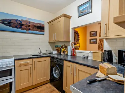 a kitchen with wooden cabinets and a dishwasher at 2 Bed in Keswick 80515 in Keswick